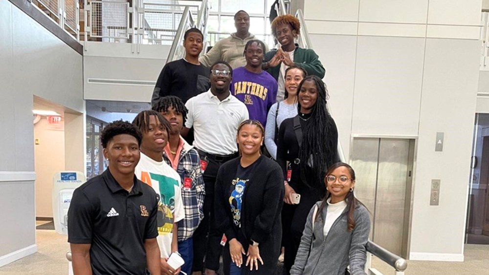 FOSSI Scholars pose on the steps of Chevron Phillips Chemical Company with Vander Breland, Project Assurance Engineer, CPChem